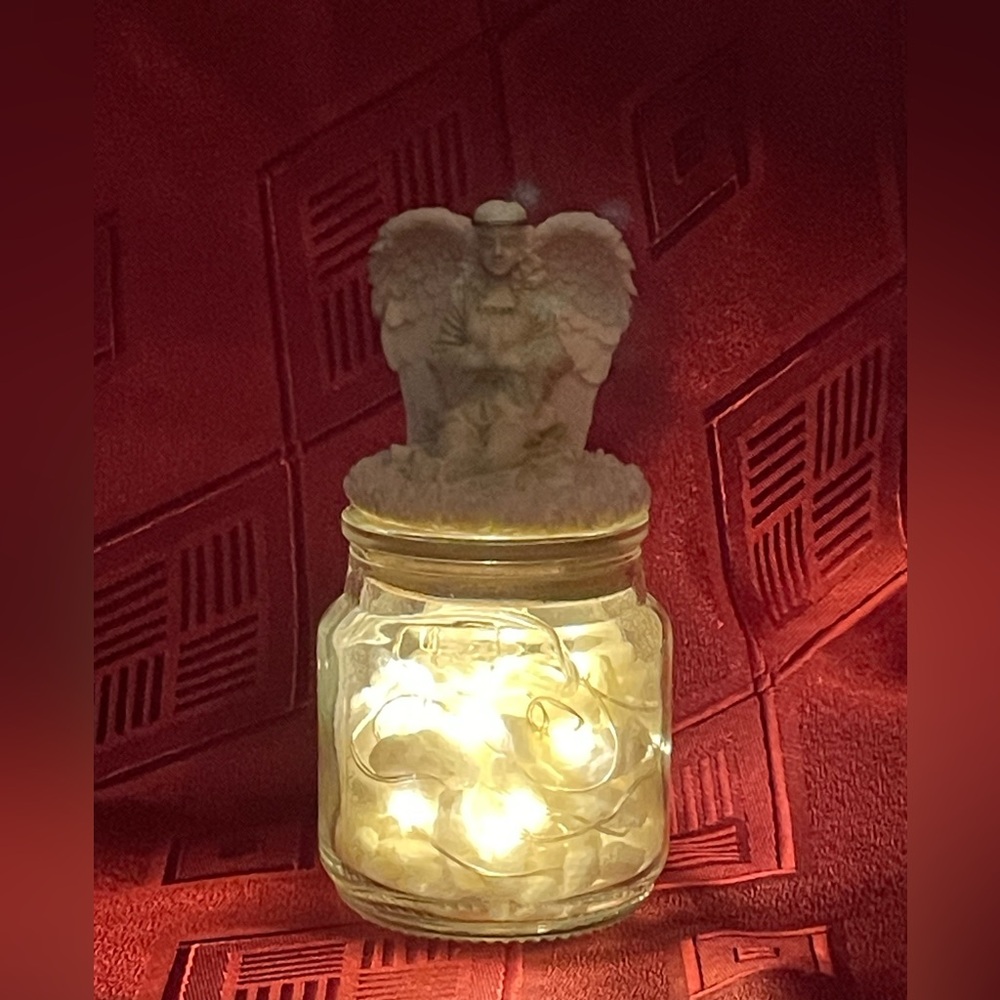 Glass votive candle jar with fairy lights in marble chips and angel topper